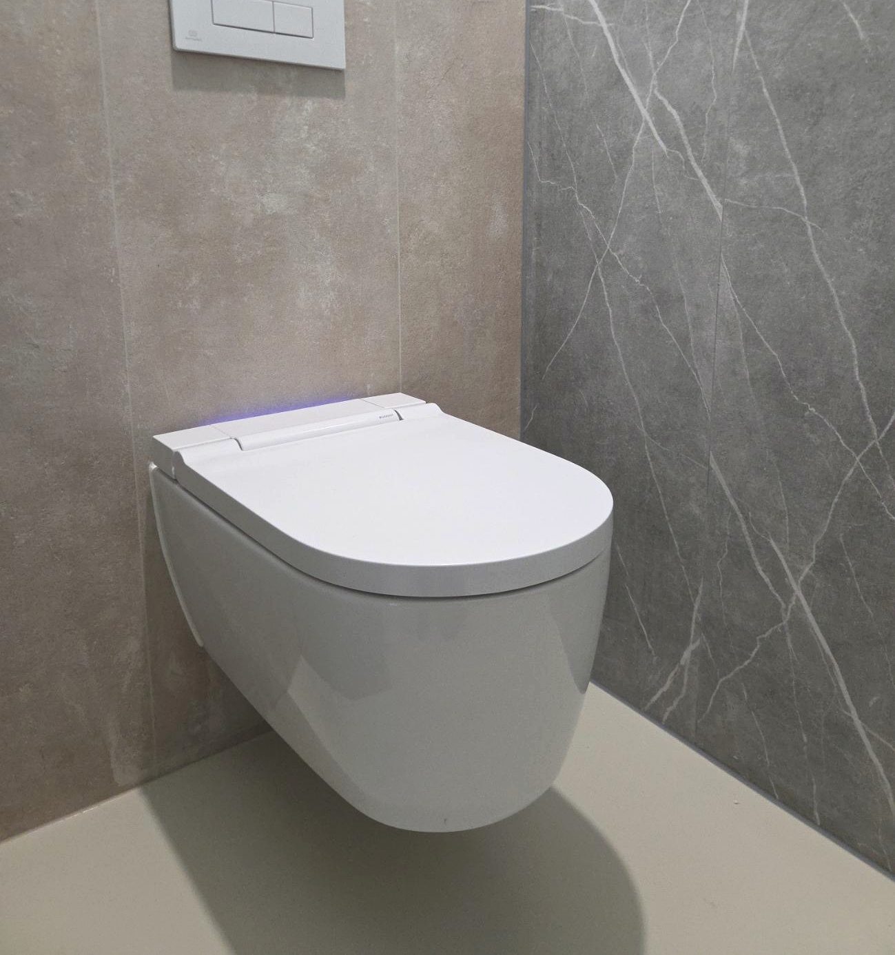 Geplaatst hangtoilet tegen grijs marmer